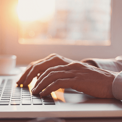 close up of hands typing on a keyboard